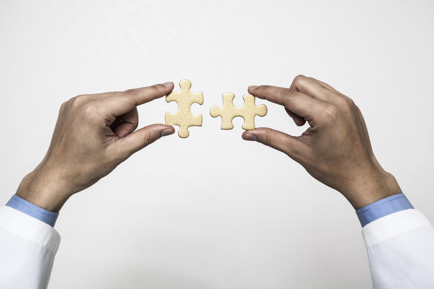 Two physicians fitting puzzle pieces together
